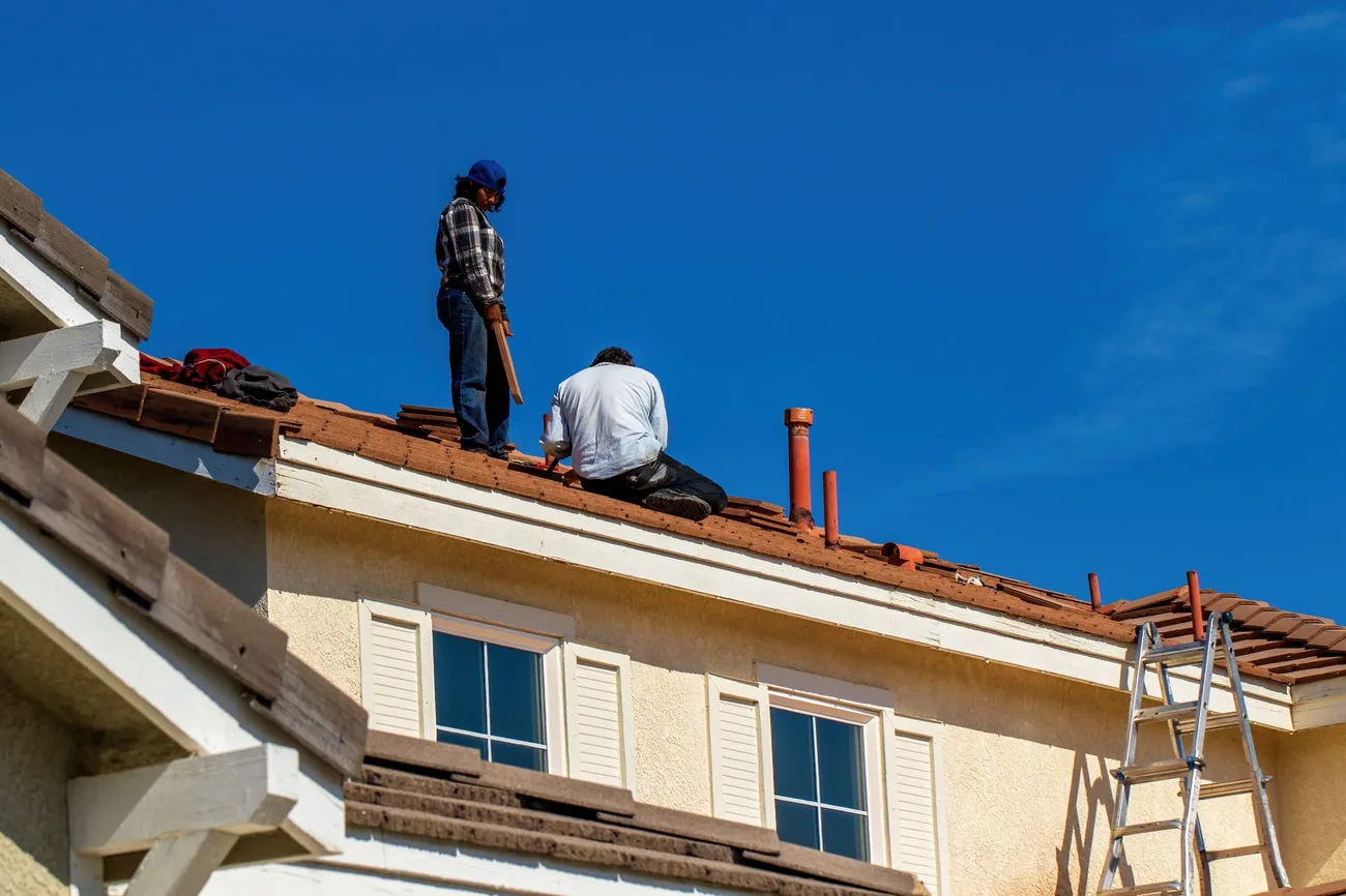 Two operatives working safely on a house roof